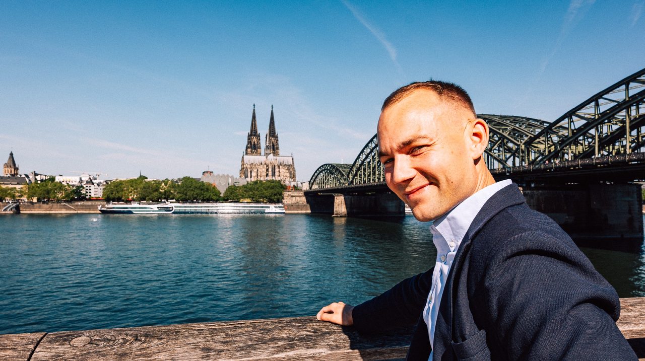 Leonard Kordowski am Rheinufer vor Dom und Hohenzollernbrücke