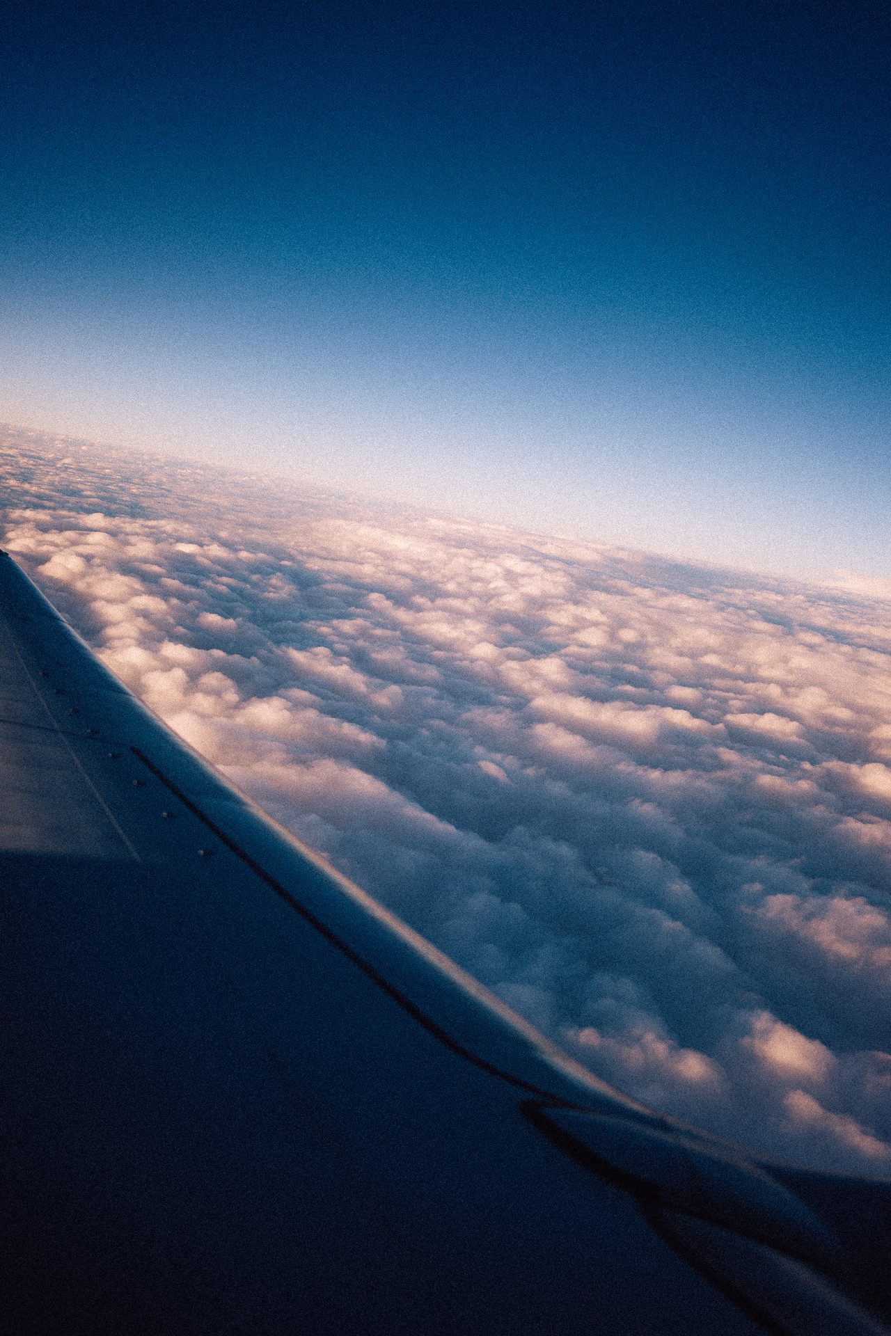 Ein Flugzeugflügel über einem geschlossenen Wolkenmeer.