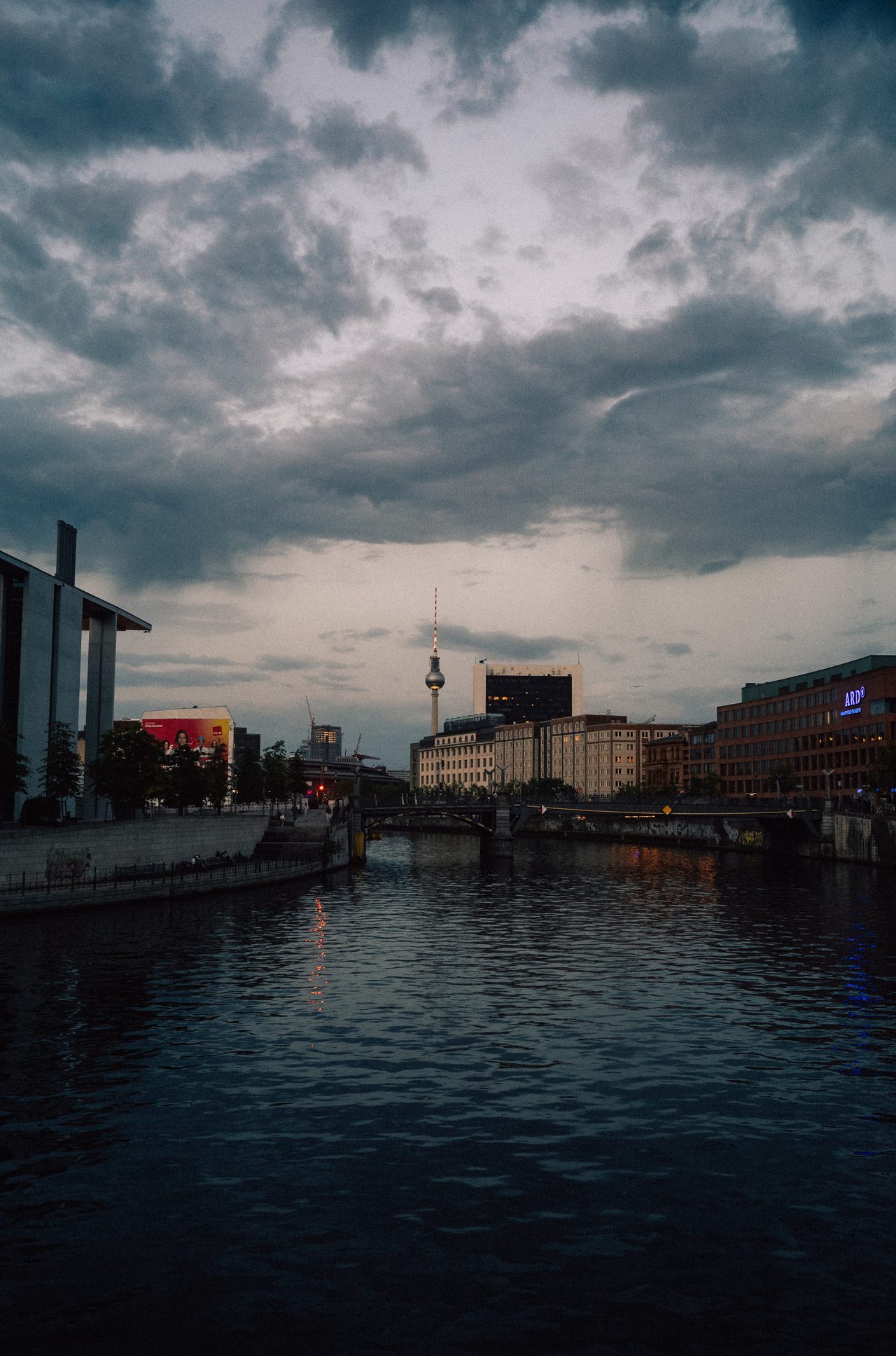 Eine Stadt und ein Fluss unter einem dramatischen Wolkenhimmel.