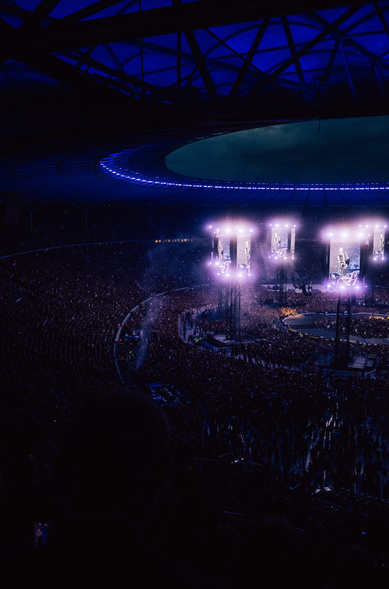 Blau beleuchtetes Stadion bei einem Konzert am Abend