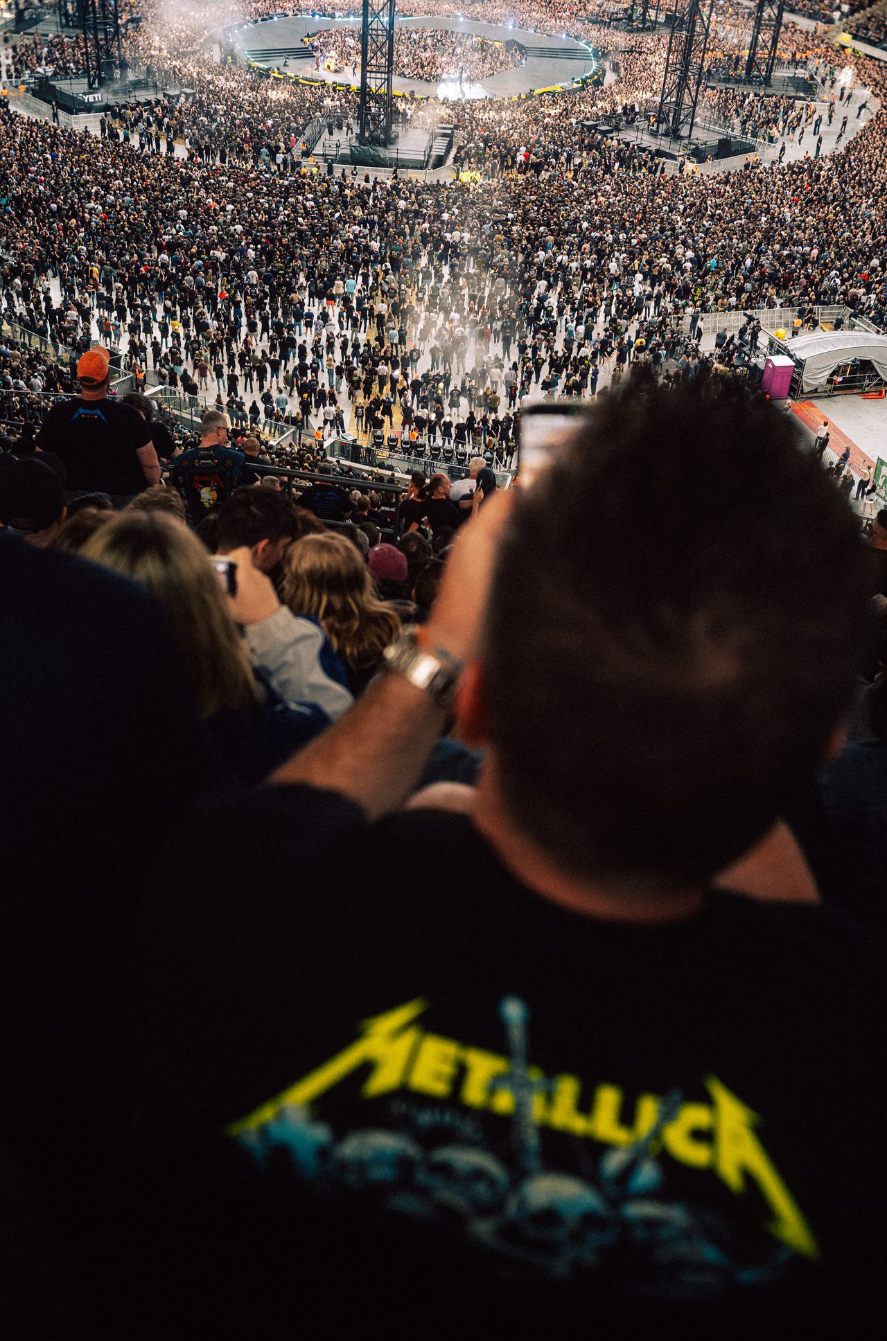 Konzertpublikum blickt von den Rängen auf die Bühne im Stadion