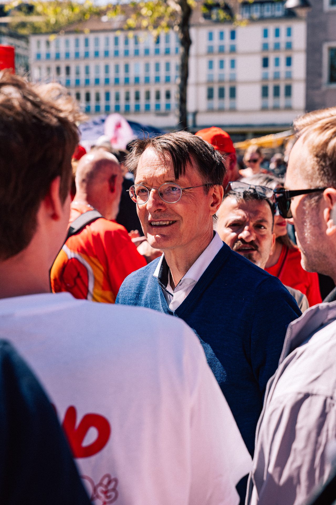 Mann mit Brille spricht inmitten einer Gruppe von Teilnehmenden