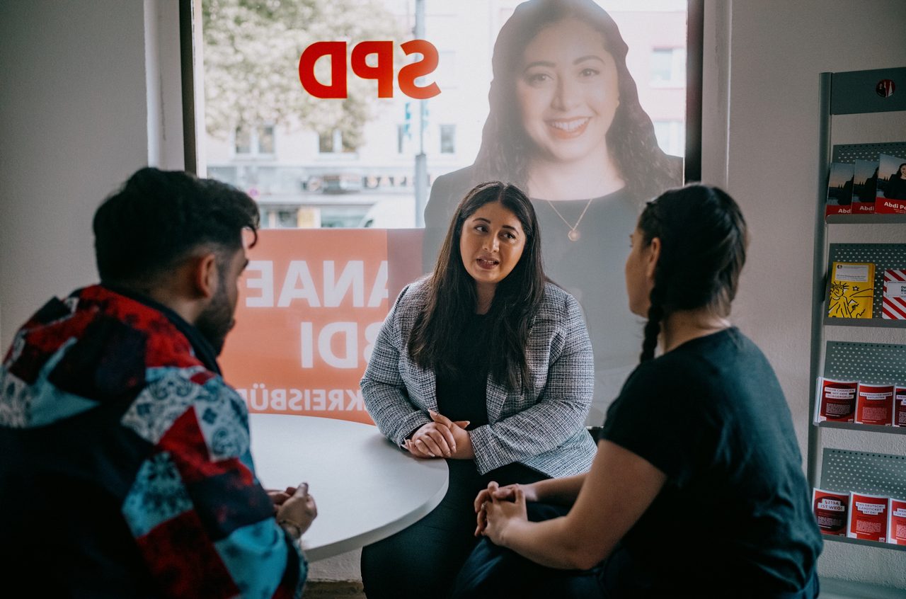 Sanae Abdi im Gespräch mit zwei Menschen im SPD-Bürgerbüro Kalk