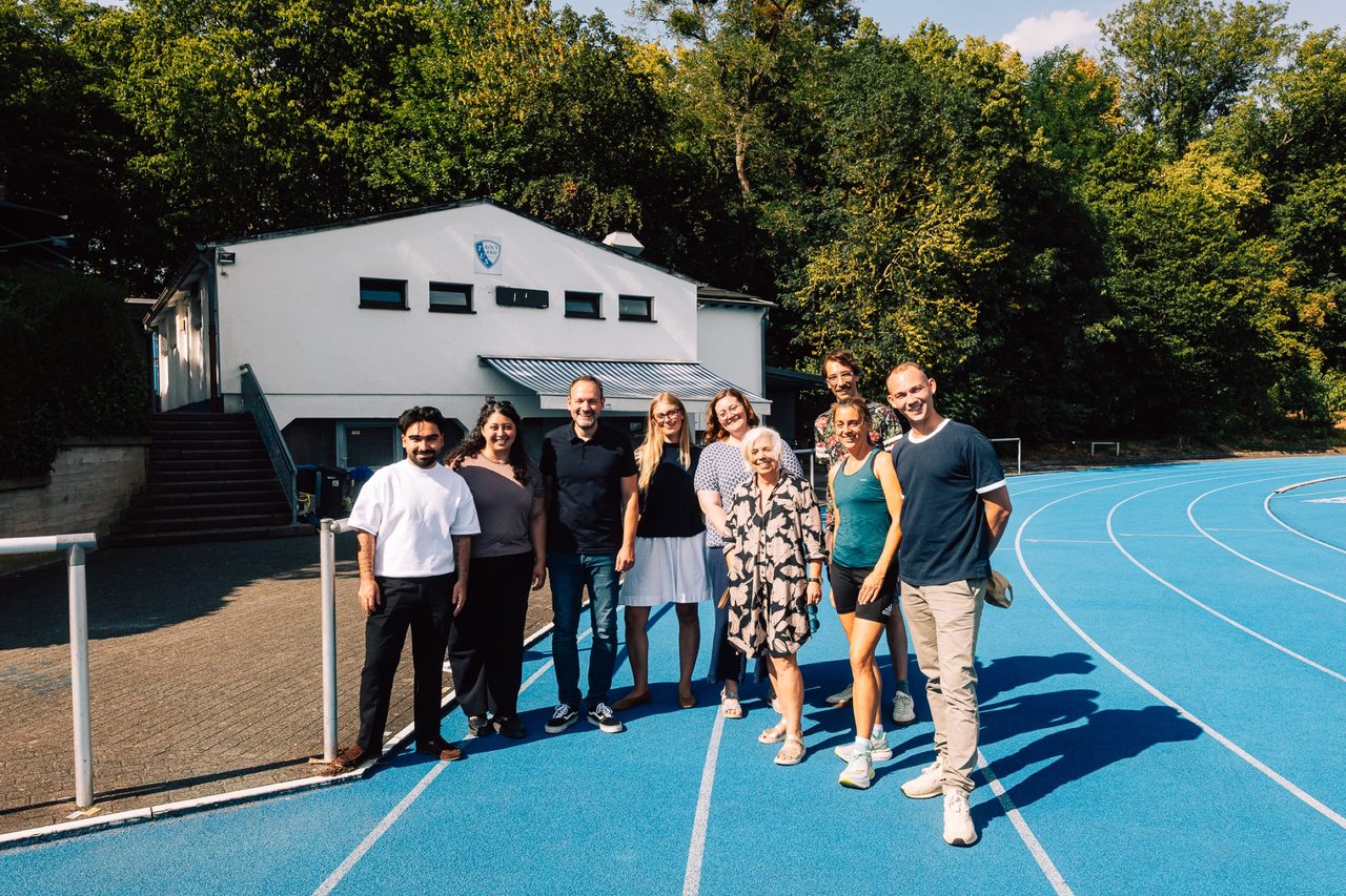 Sanae Abdi mit einer Gruppe auf einer blauen Laufbahn