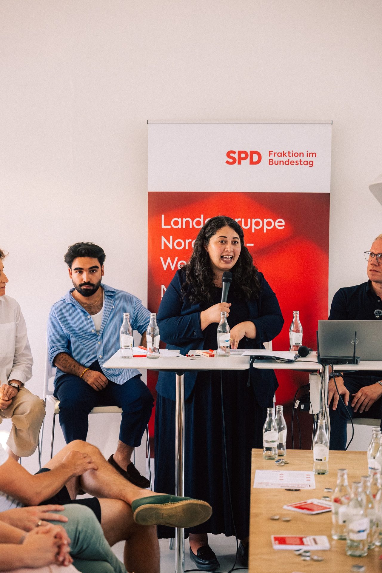 Sanae Abdi spricht auf einem Podium der SPD-Bundestagsfraktion