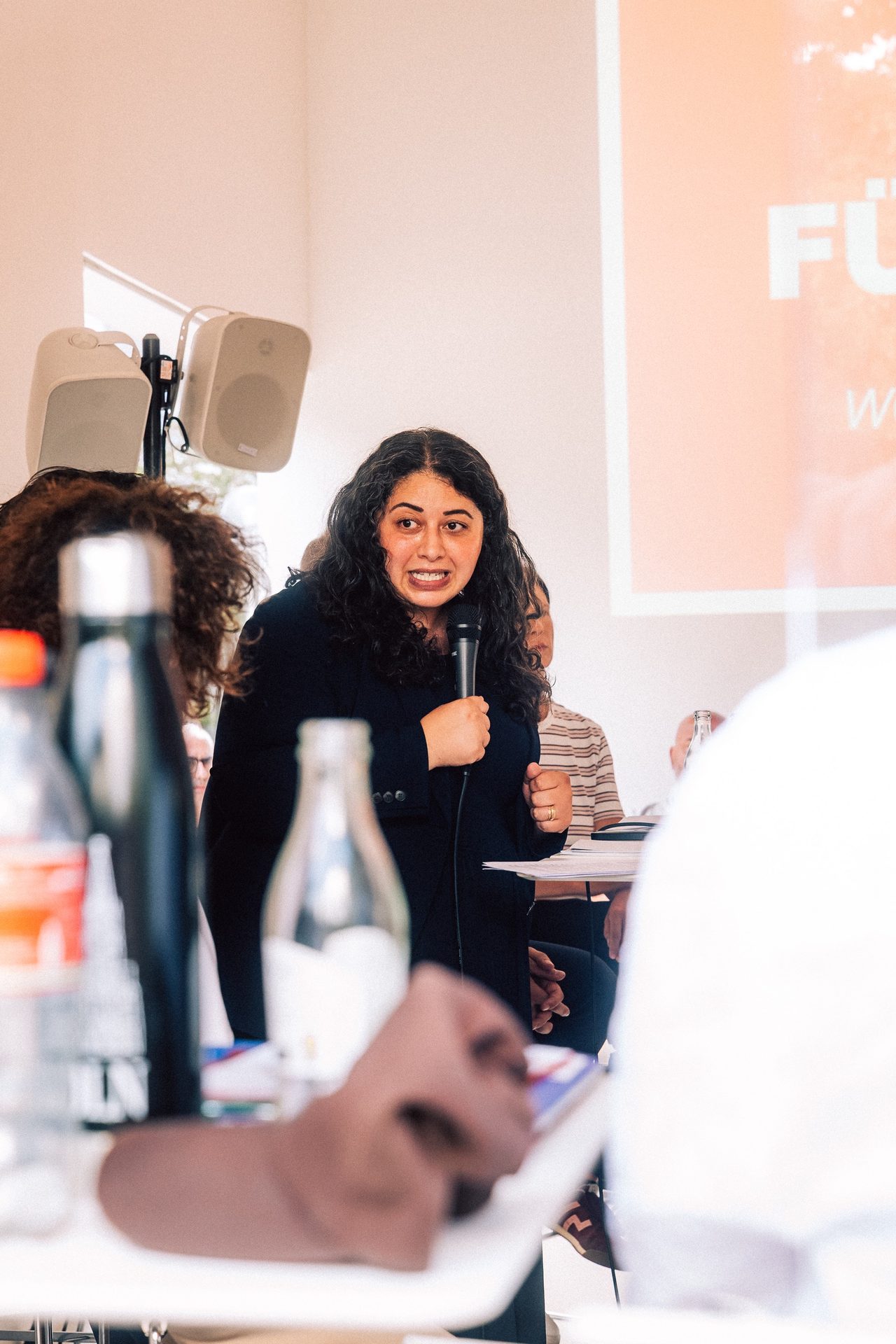 Sanae Abdi spricht bei einer Diskussionsrunde in ein Mikrofon
