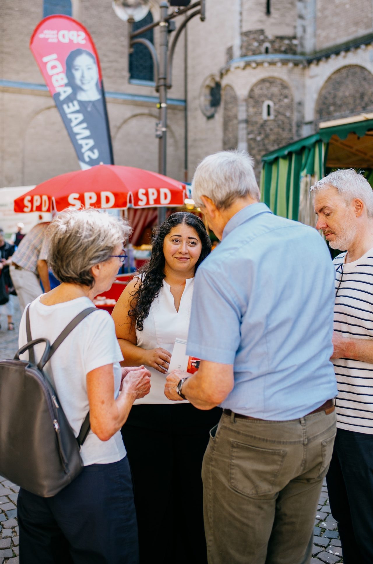 Sanae Abdi spricht mit einer Besuchergruppe am SPD-Infostand