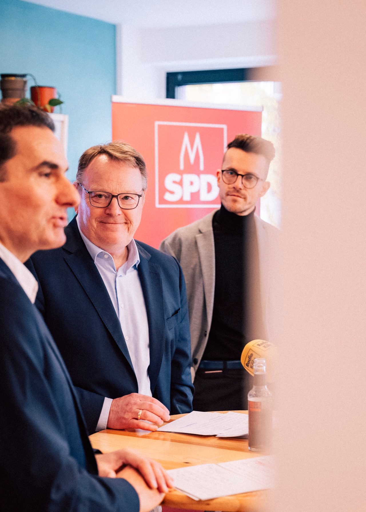Thorsten Burmester mit Gesprächspartnern vor einem SPD-Banner