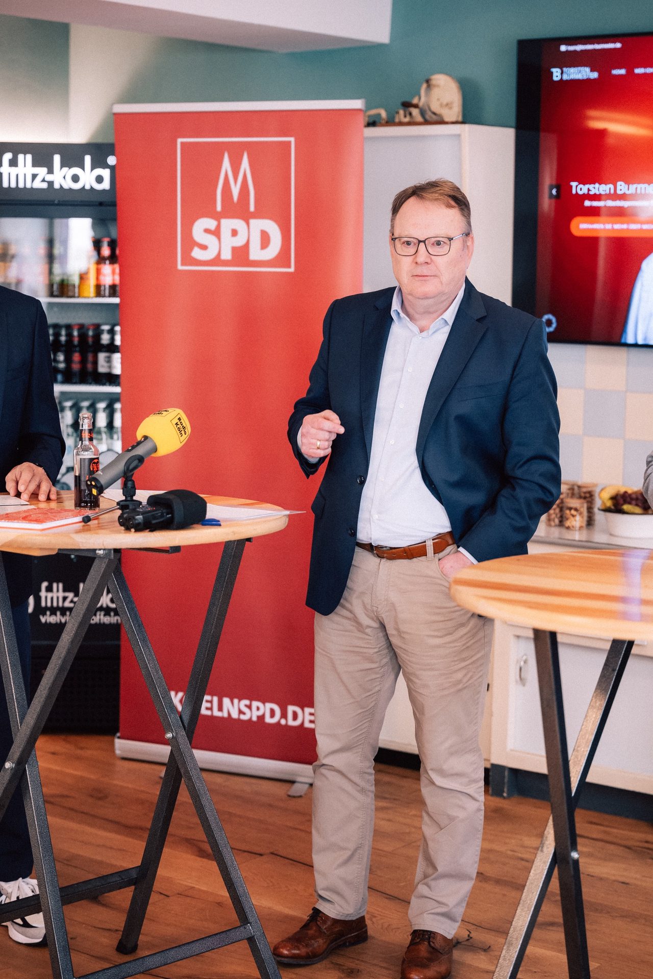 Thorsten Burmester spricht an einem Stehtisch vor einem SPD-Banner